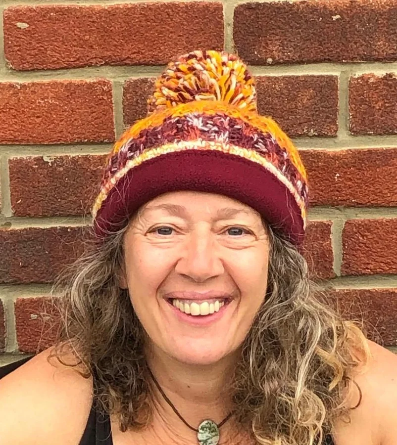 Lynn smiling in a knitted hat