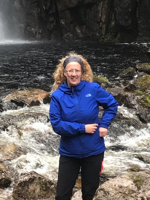 Lynn beside running water in the hills