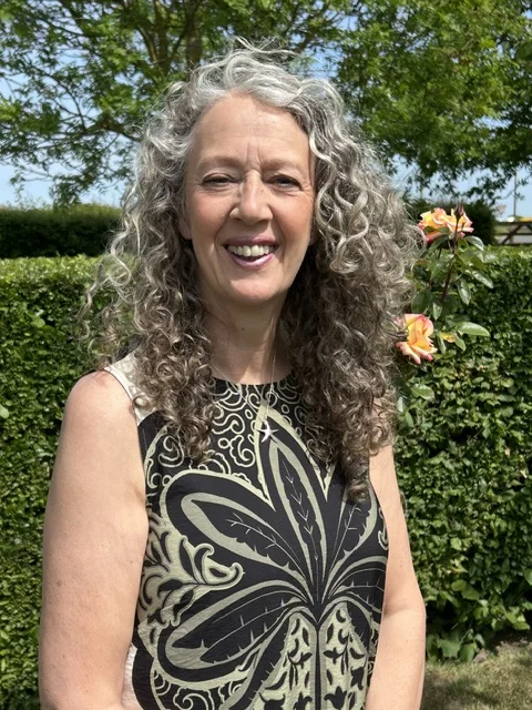 Lynn smiling in a garden