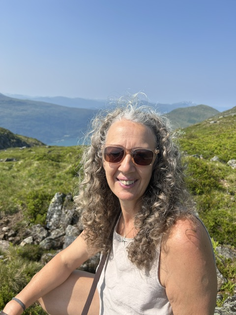Lynn smiling in the Scottish mountains