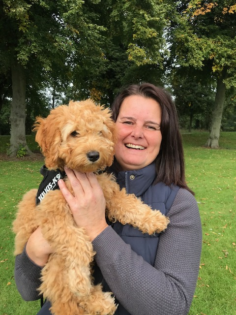 A woman with a golden doodle outdoors